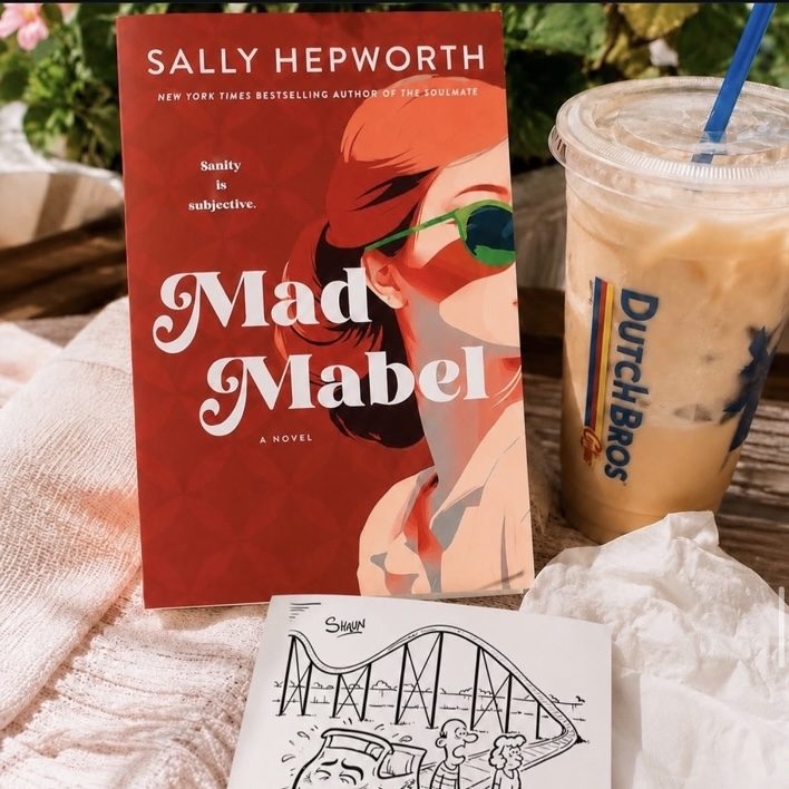 Mad Mabel by Sally Hepworth beside an iced coffee and a hand-drawn roller-coaster illustration.